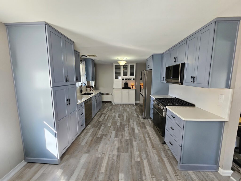 Kitchen Remodeling in York, PA: What We Found After Demolition in an Older Home Modern kitchen remodel in York PA with blue shaker cabinets, quartz countertops, stainless steel appliances, and gray wood-look flooring